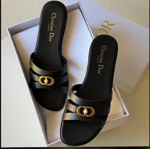 Mules plates noires élégantes avec boucle dorée