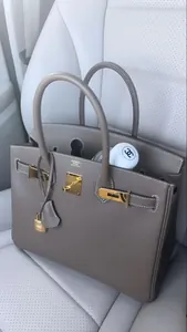 Sac à main élégant gris taupe avec détails dorés